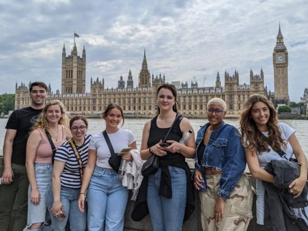 Students standing along the River Thames with the Houses of Parliament and Big Ben in the background.