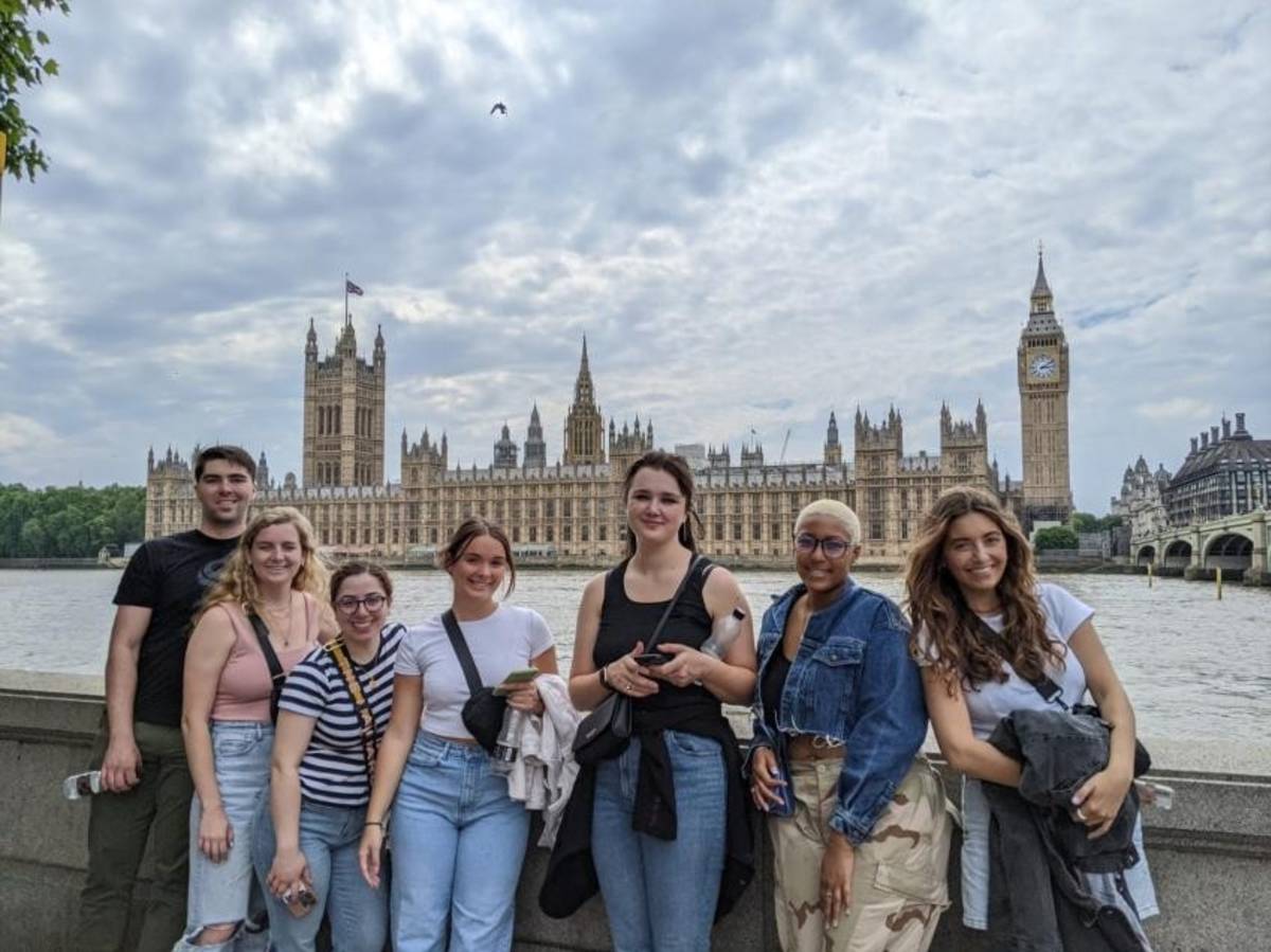 Students standing along the River Thames with the Houses of Parliament and Big Ben in the background.