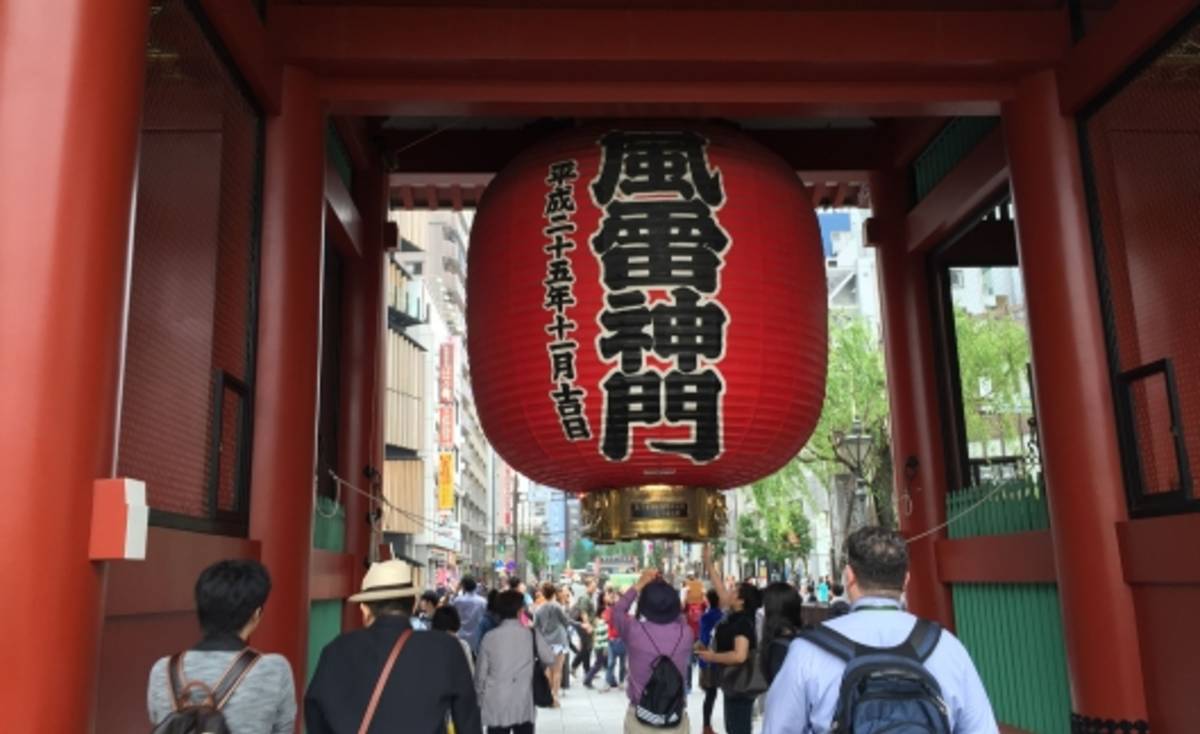 Students under giant red lantern in Japanese temple