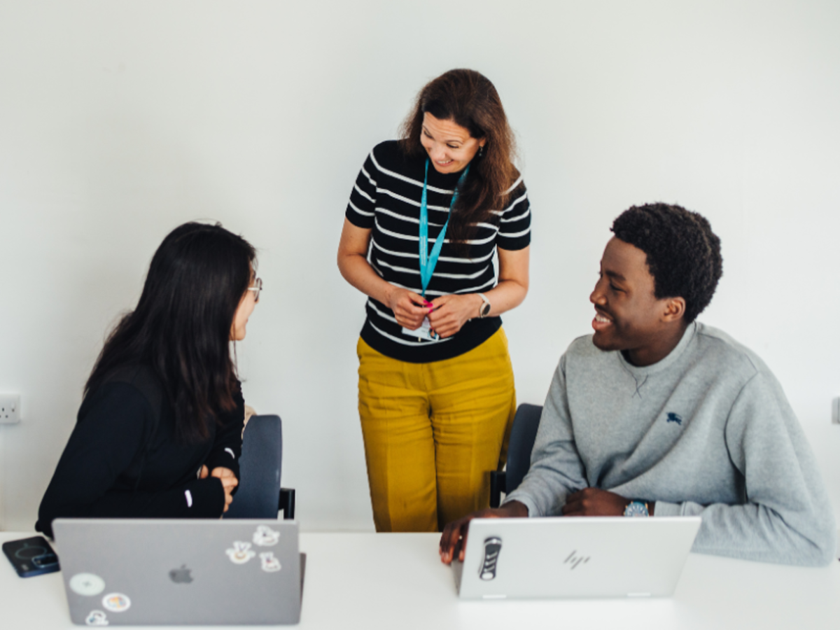 Teacher and two students discussing work