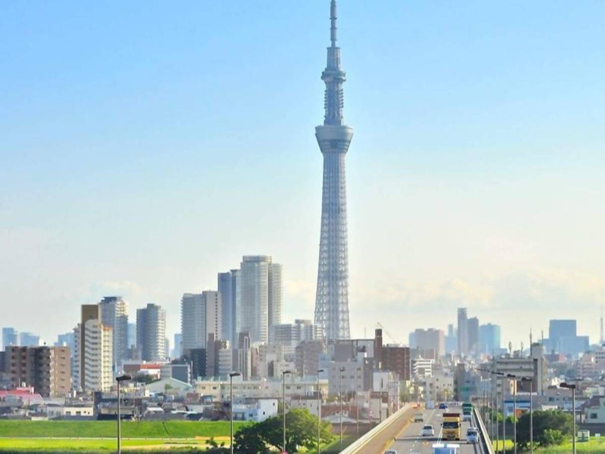 The Tokyo skyline and a busy highway with cars driving along it.