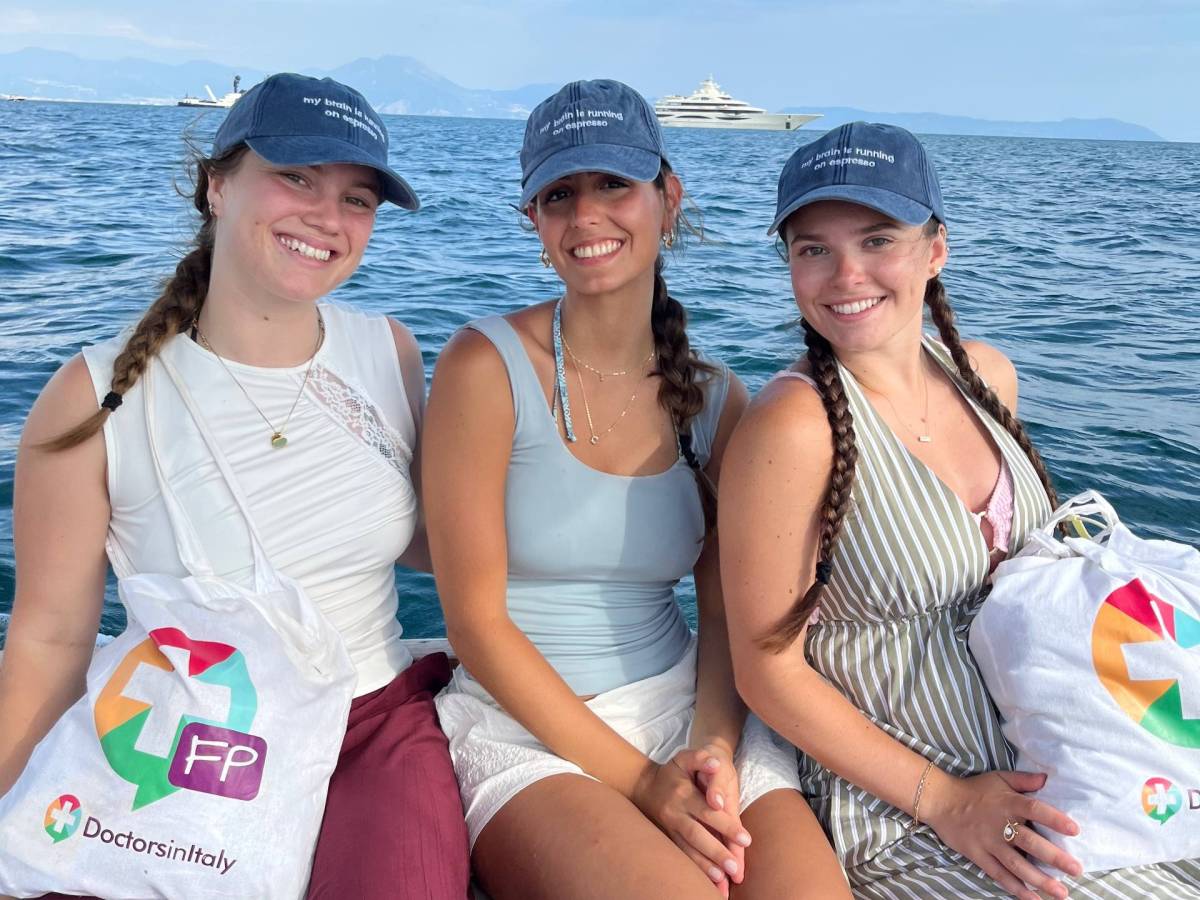 Three fellows dressed in Doctors in Italy merchandise, sitting on a boat tour.