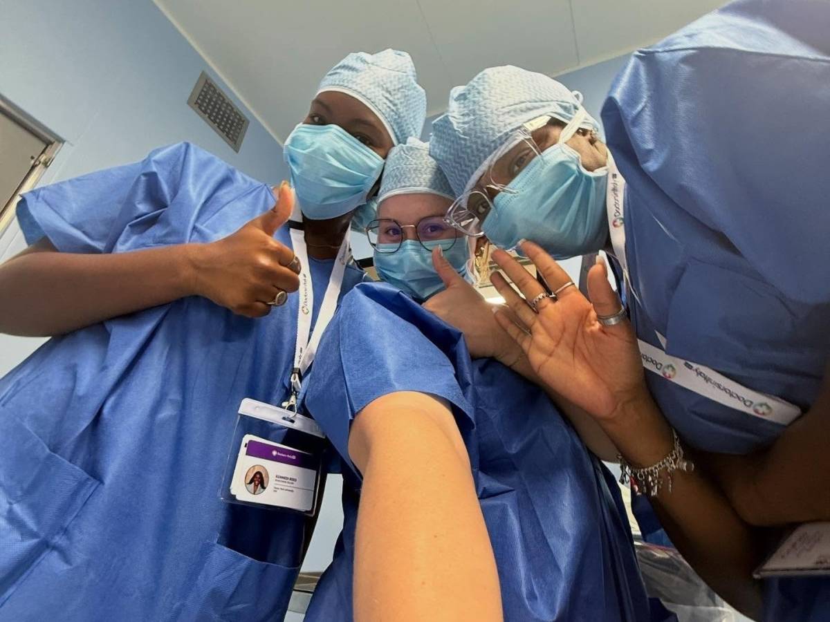 Three fellows in their scrubs and masks on taking a quick selfie.
