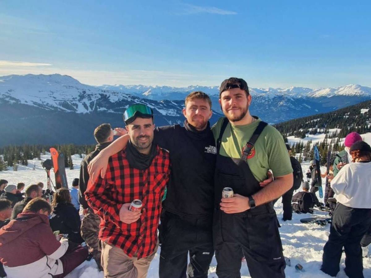 Three people on top of a snowy mountain