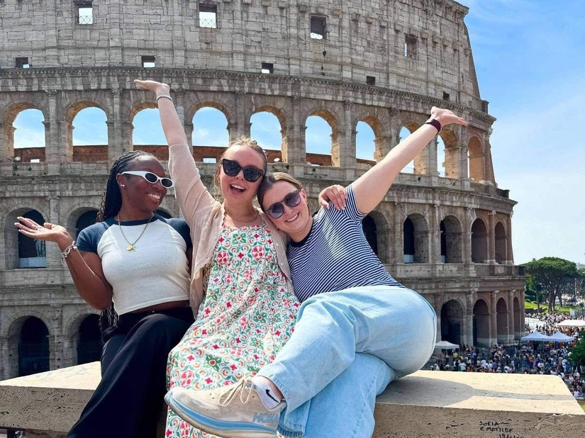 Three students posing in front of the Colosseum in Rome, Italy.