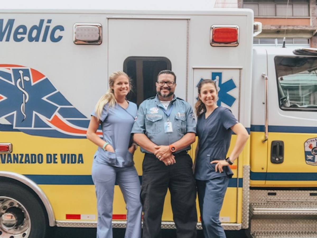 Three Volunteers standing with an Ambulance in Costa Rica