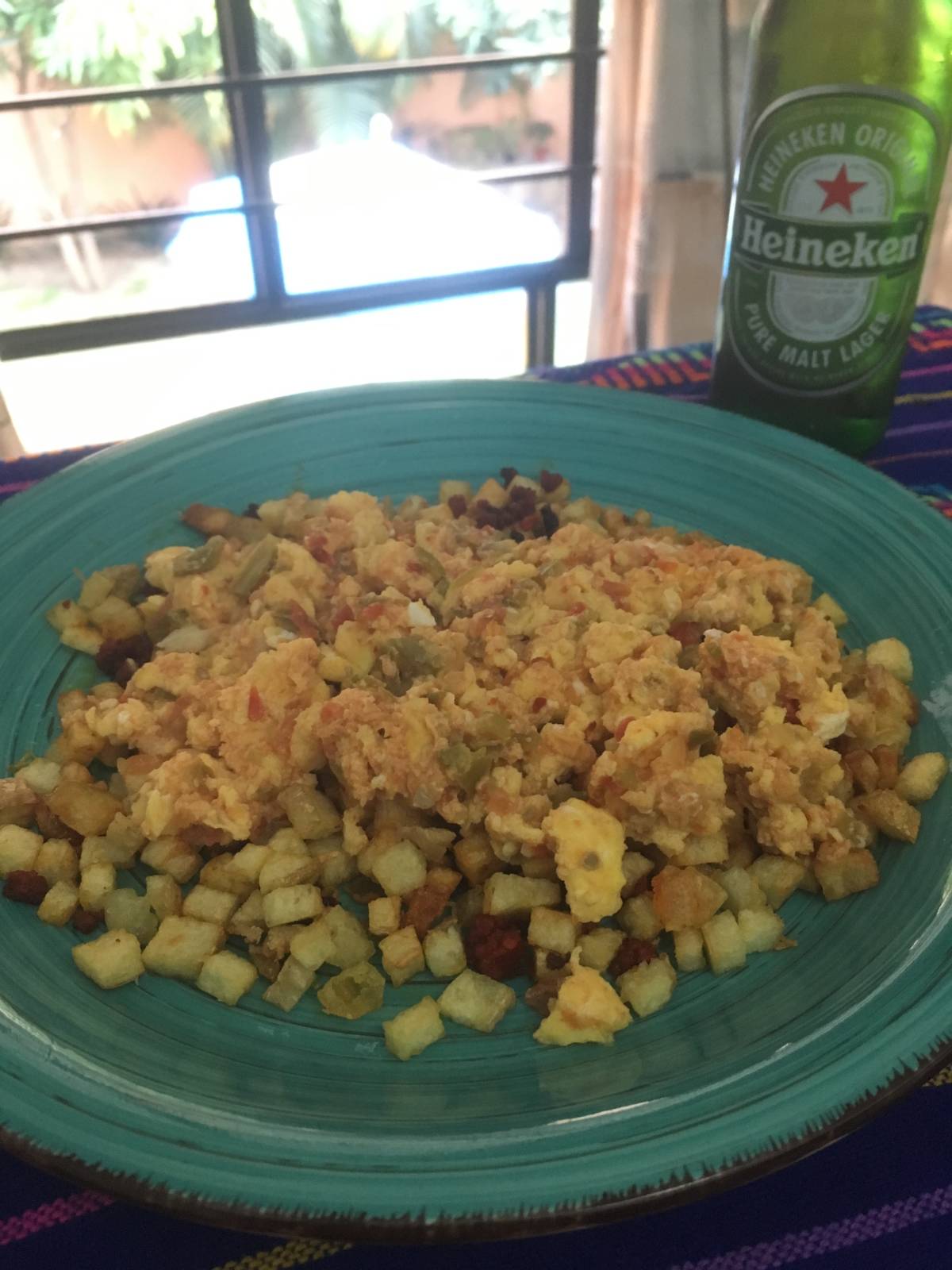 Traditional Mexican breakfast with eggs, tortillas, salsa, and fresh ingredients served on a plate.
