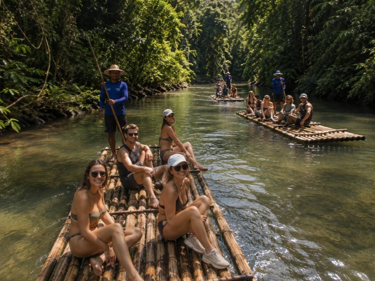 Travellers bamboo rafting through a tropical rainforest