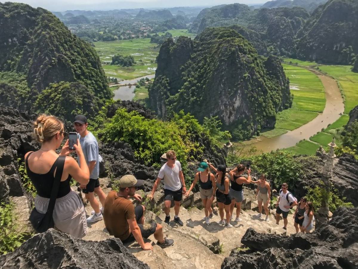 Travellers climbing to a panoramic viewpoint in Ninh Binh