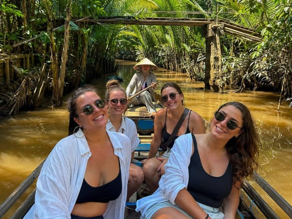 Travellers exploring a Mekong Delta canal by wooden boat