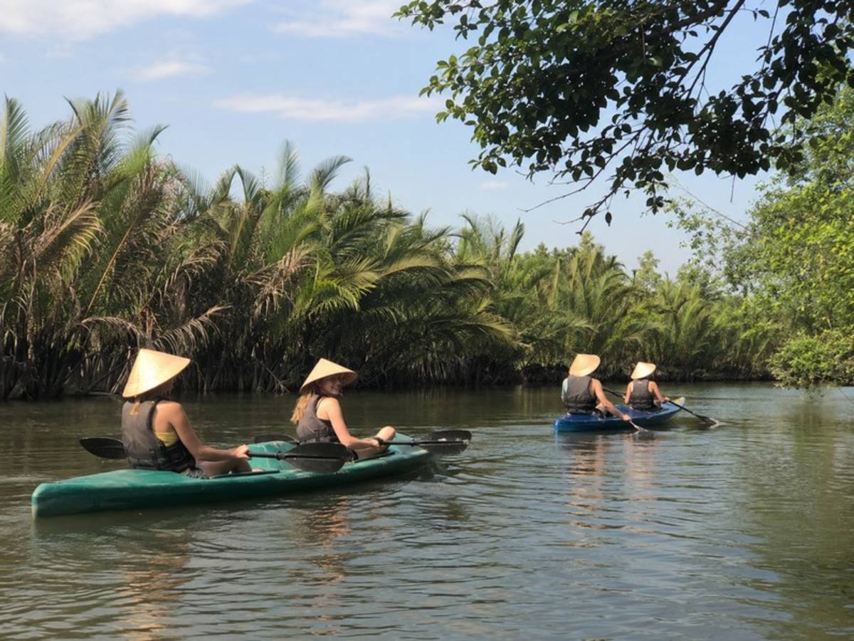 Travellers kayaking through a palm forest in Vietnam