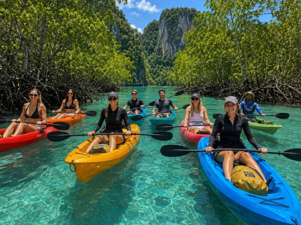 Travellers kayaking through clear tropical water in Thailand