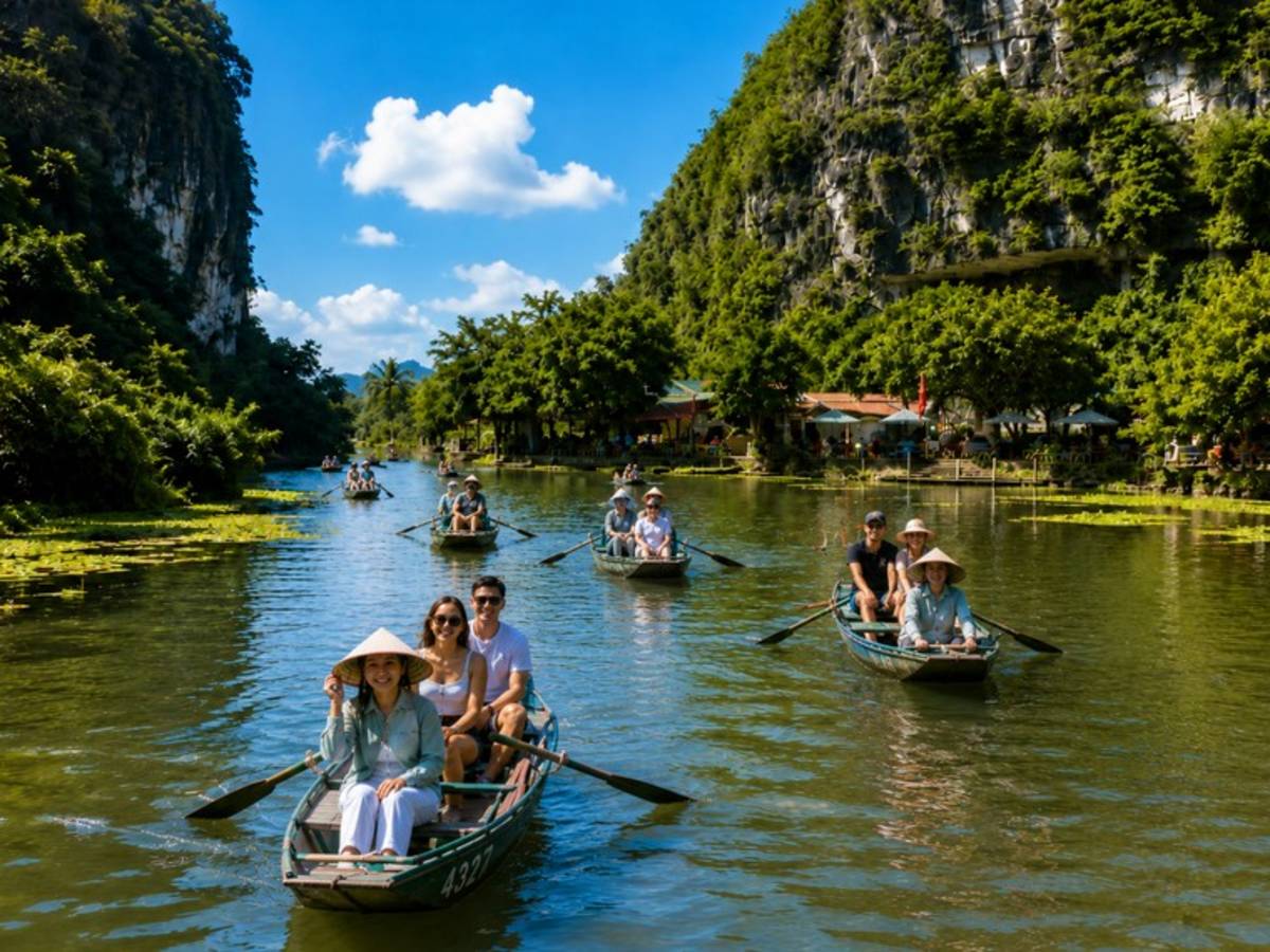 Travellers rowing boats through a limestone valley in Vietnam