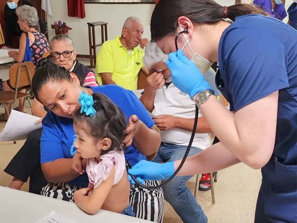 Two Female Volunteers Performing a Check-up on a Child