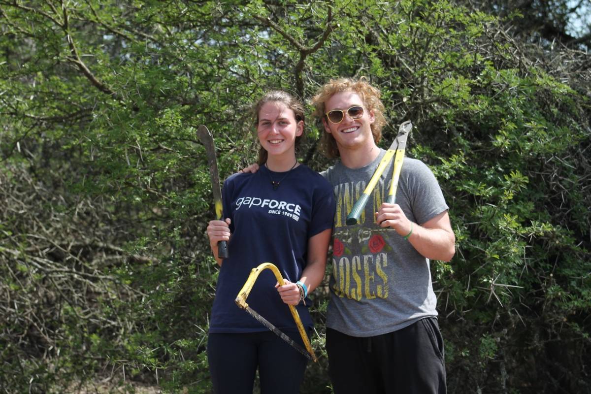 two people pose with yard tools