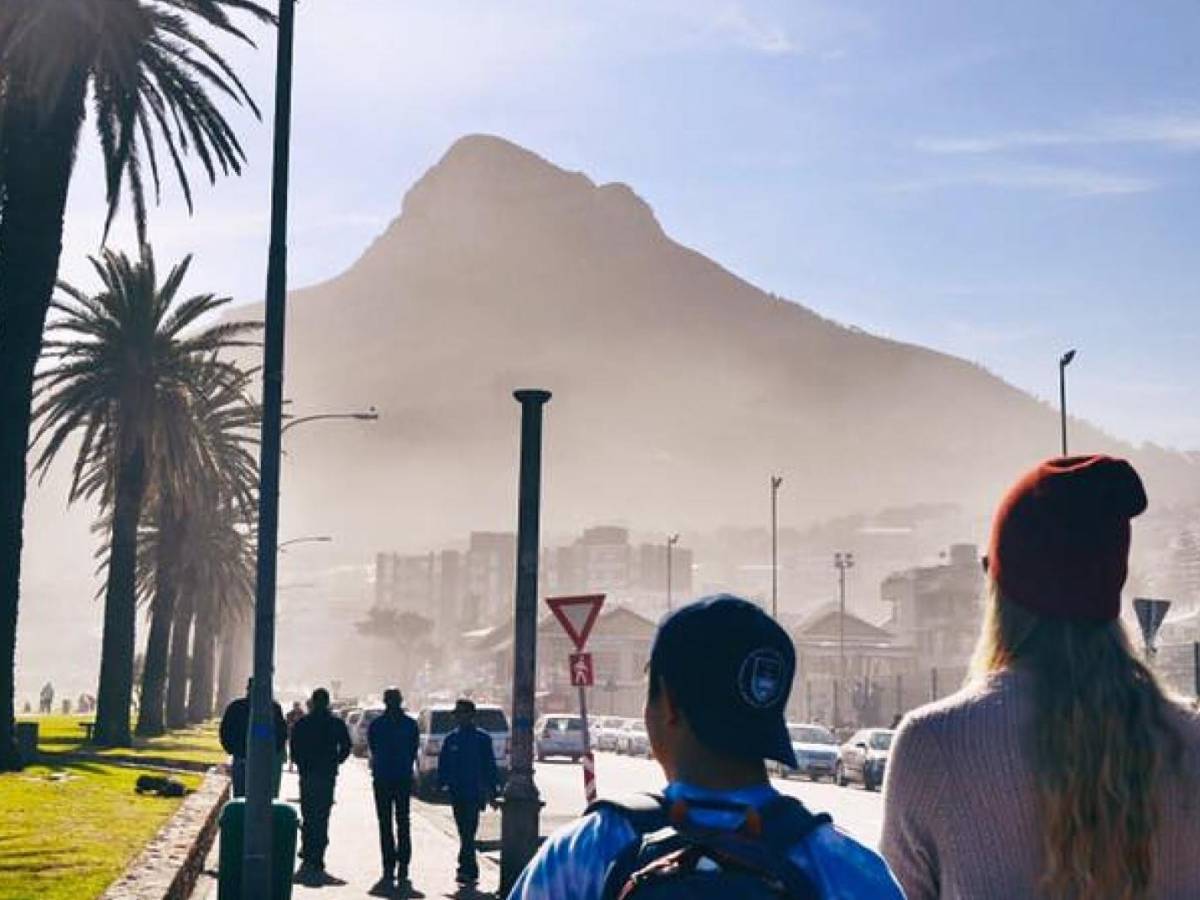 Two students in front of a scenic promenade near the ocean in Cape Town