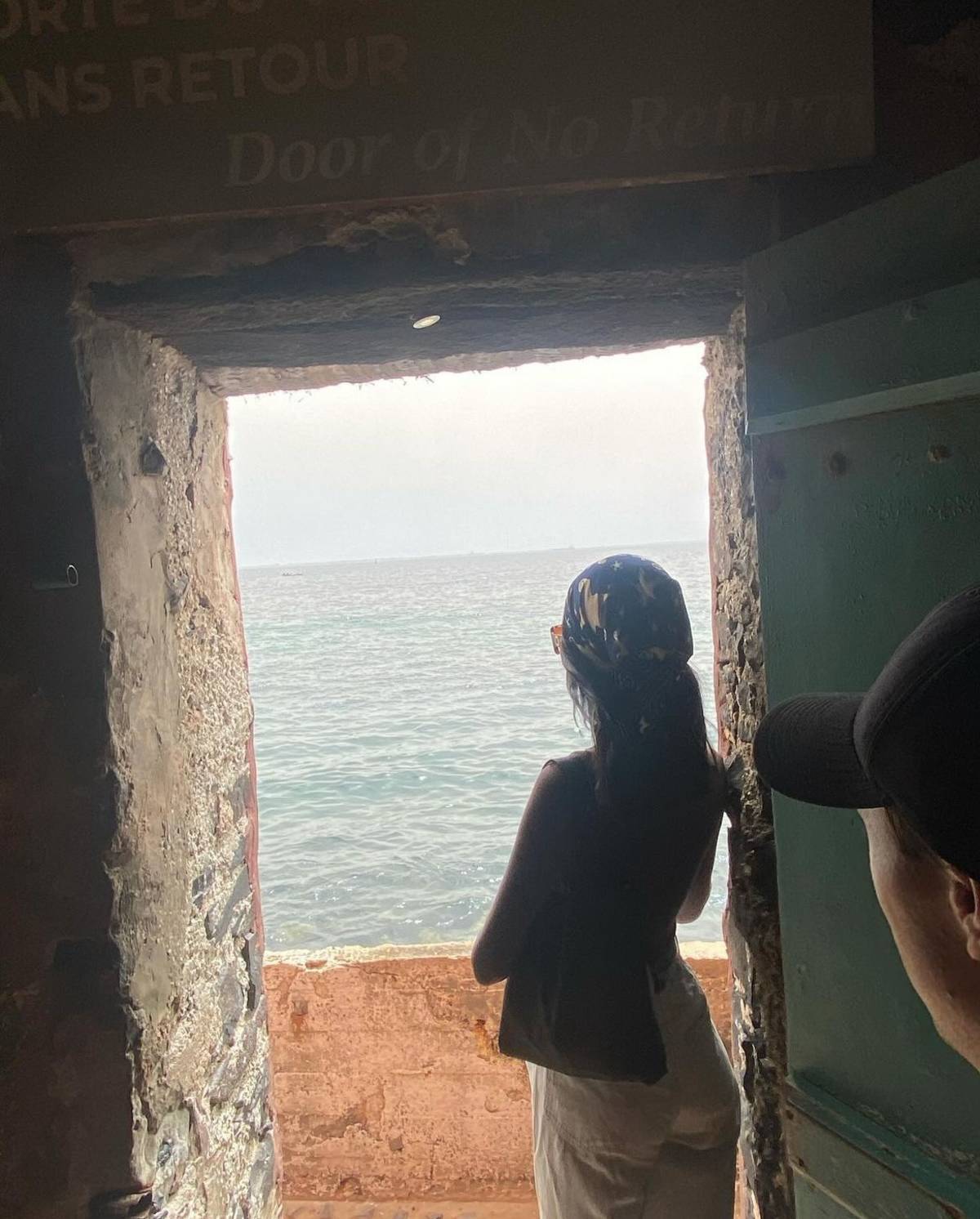 two students looking out the window to the sea on Goree Island.