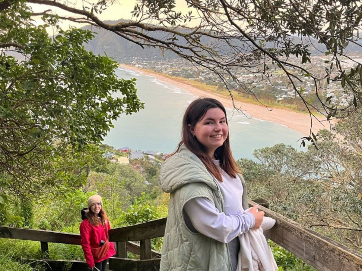 Two women on a sunrise hike with ocean views in the back