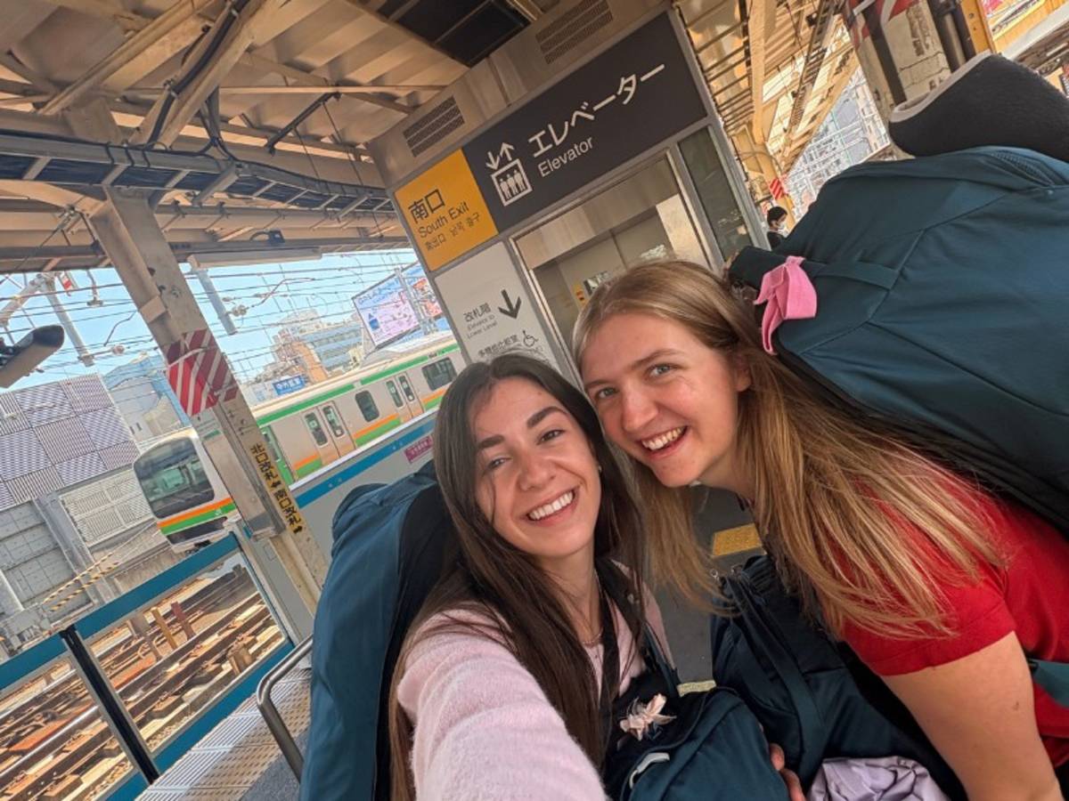Two women taking a selfie at a train station in Japan