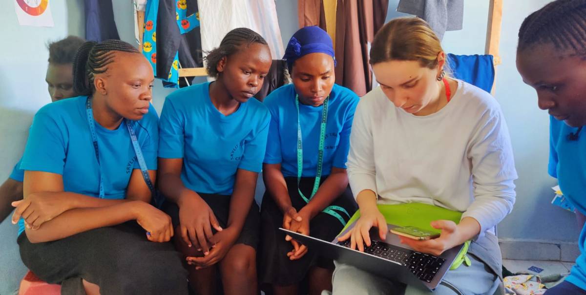 UCESCO volunteer with local youth looking at the laptop