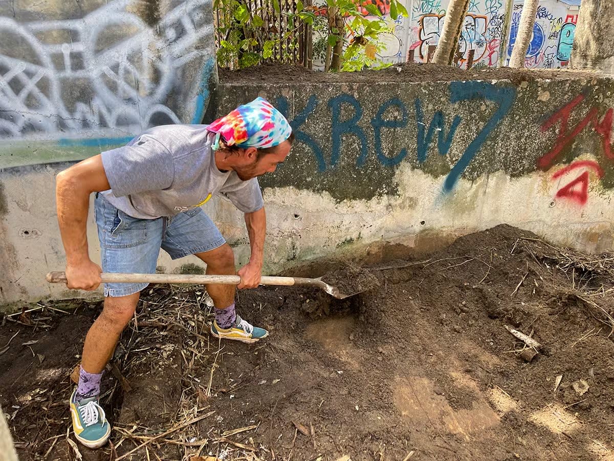 Volunteer digging soil with a shovel during a community clean-up