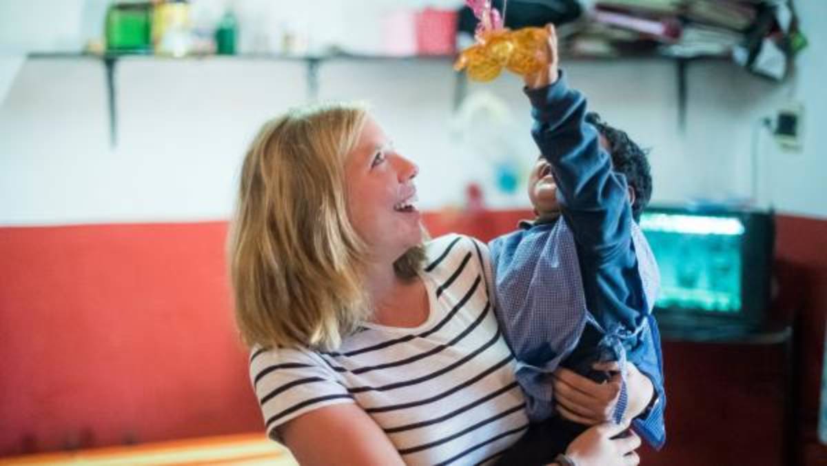 a volunteer carrying a toddler
