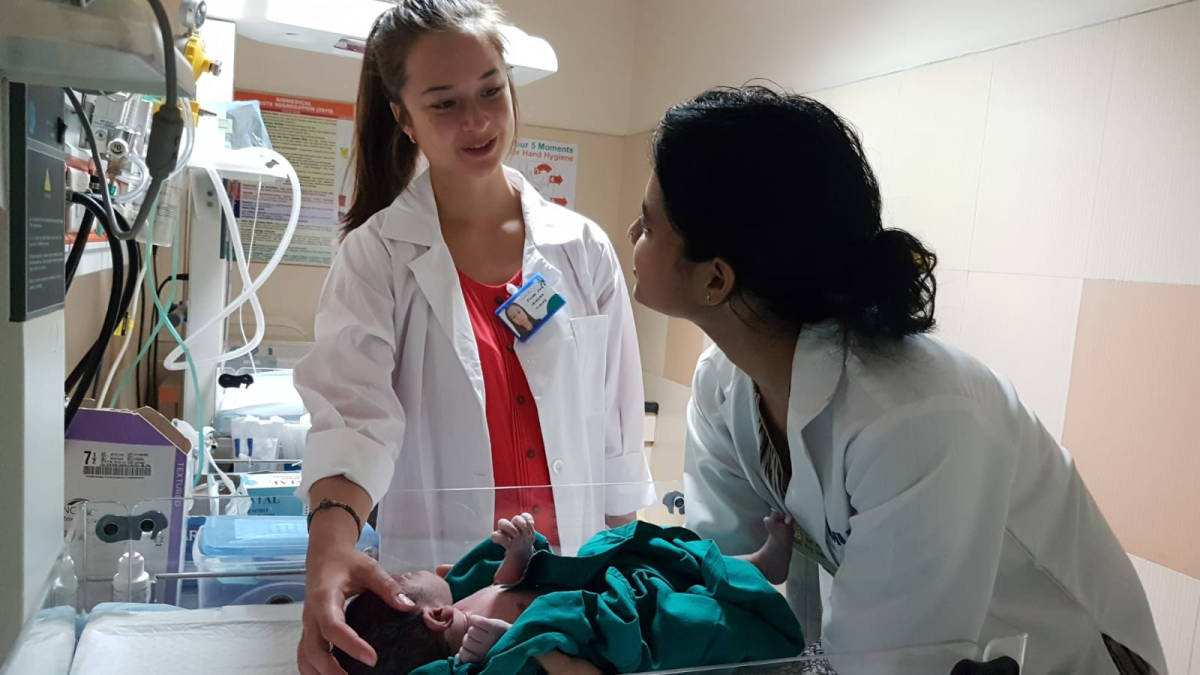 volunteer, local medical staff talking and holding baby