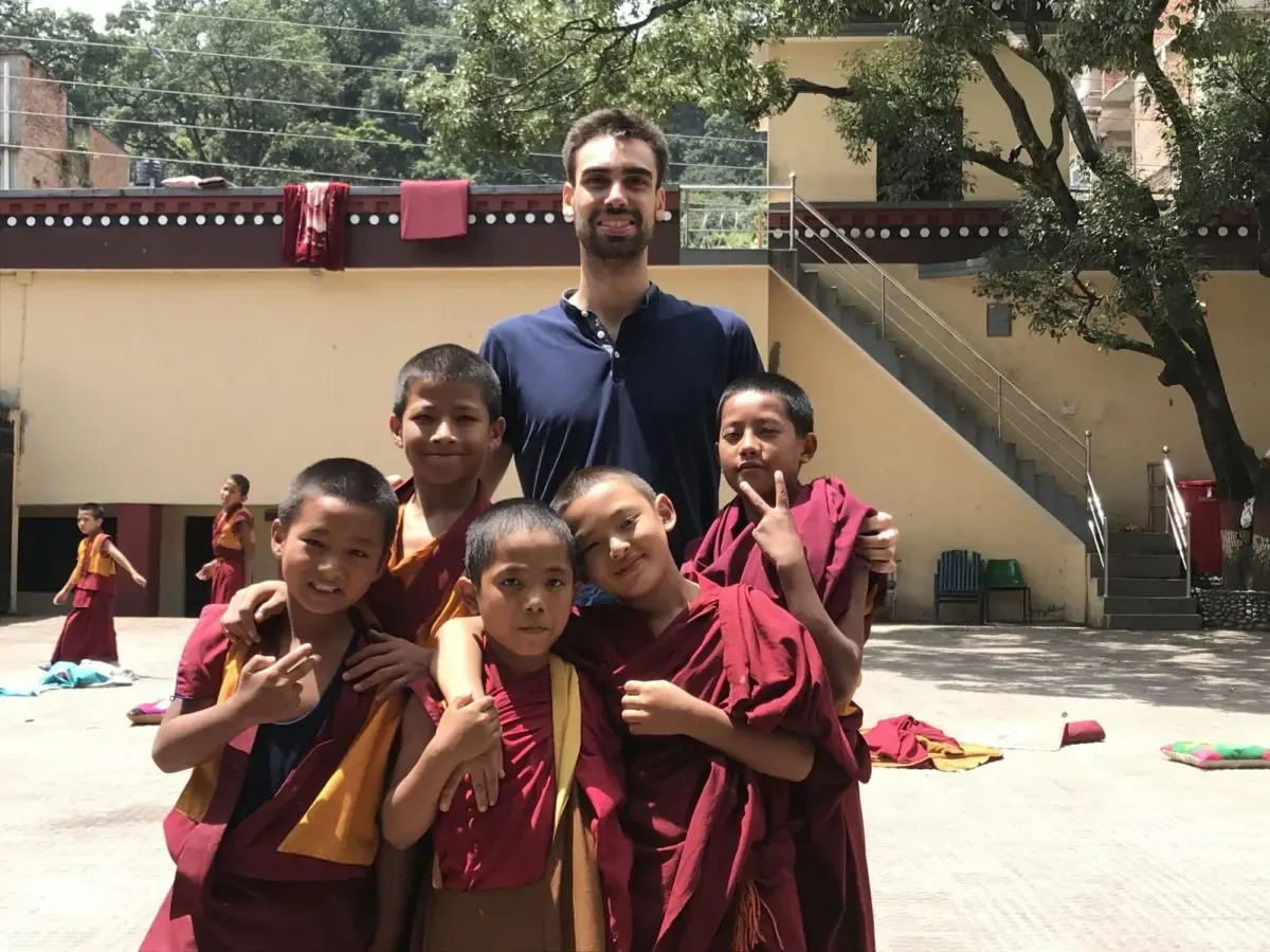 volunteer posing with monk children