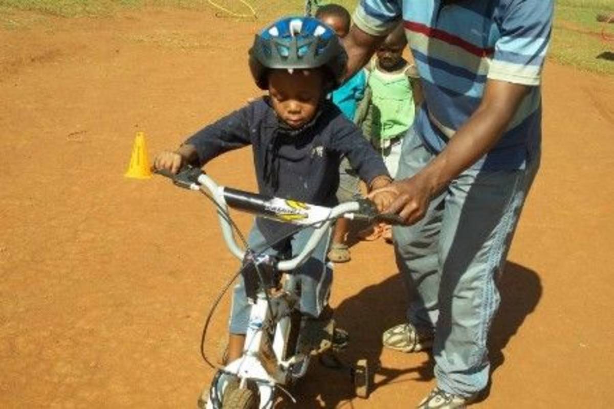 volunteer teaching a child to ride a bike