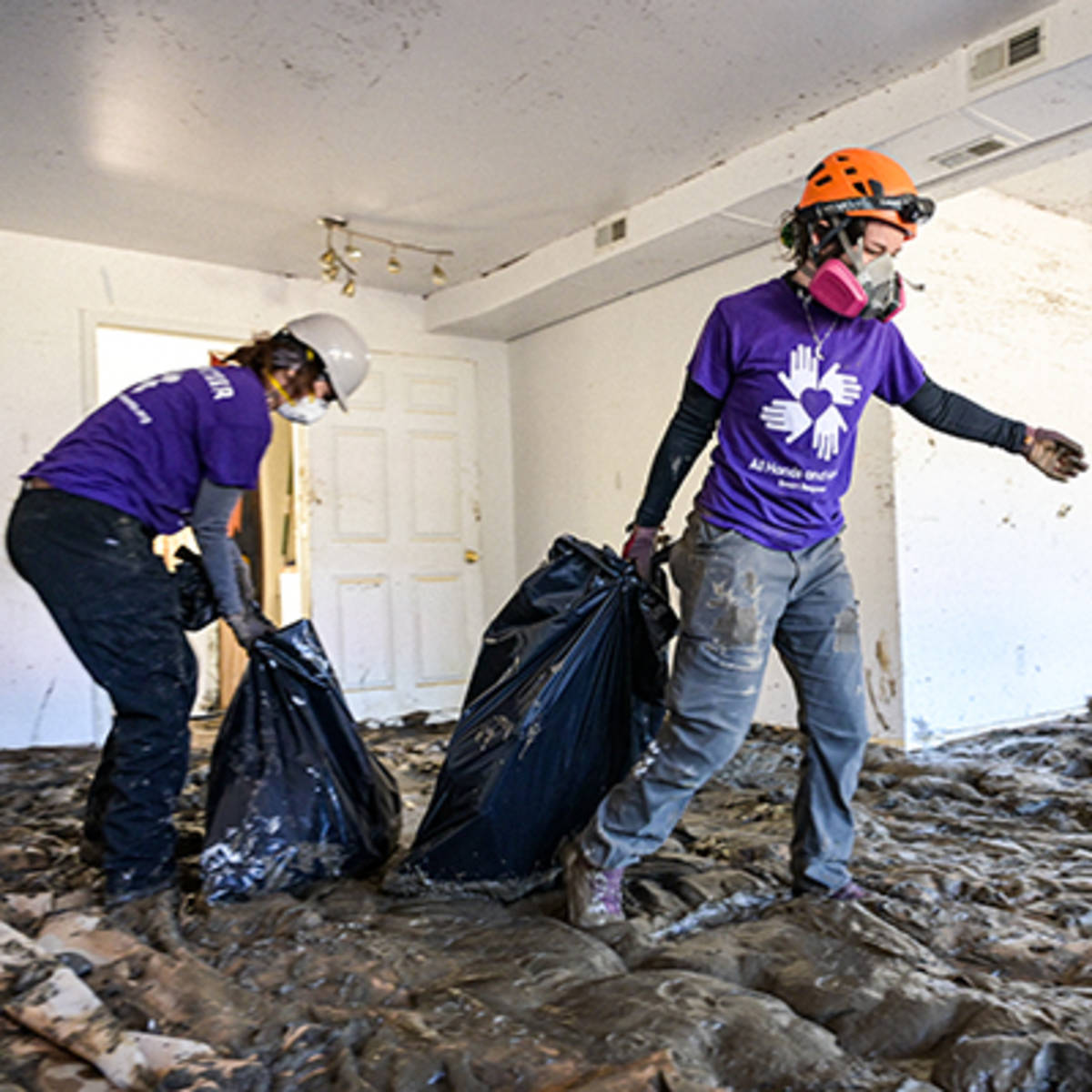 Volunteers muck out a house affected by Hurricane Helene