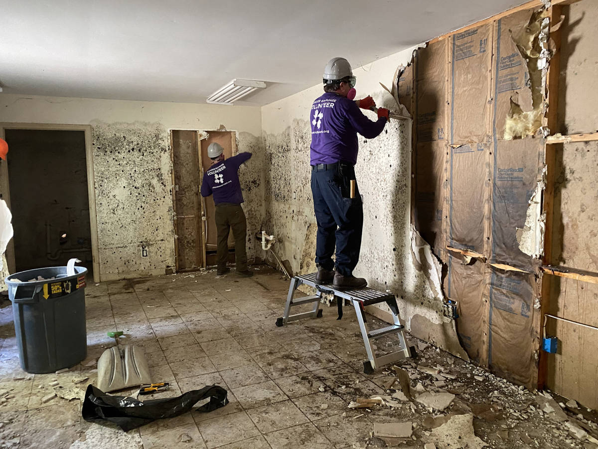 Volunteers remove moldy drywall