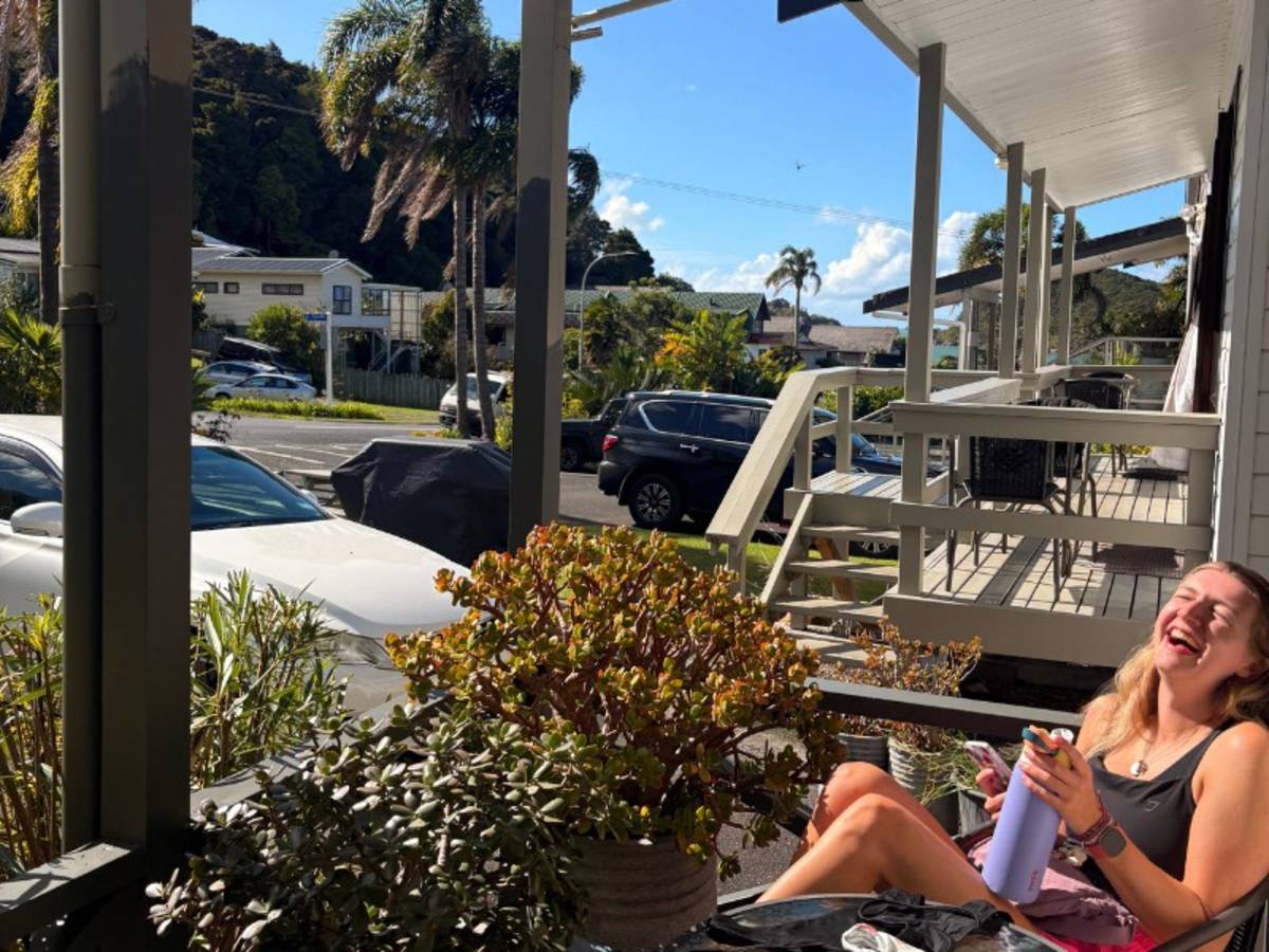 Woman laughing whilst siting on a porch