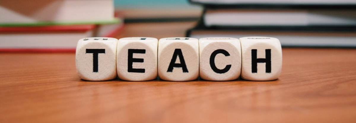 Word game tiles with the letters spelling the word teach