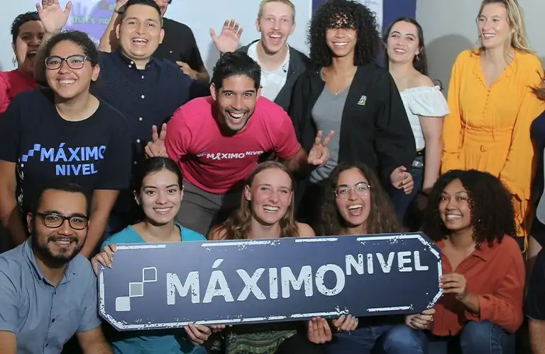 students holding a Maximo Nivel banner