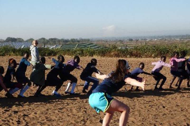 Zambia sports volunteer giving warm up instructions