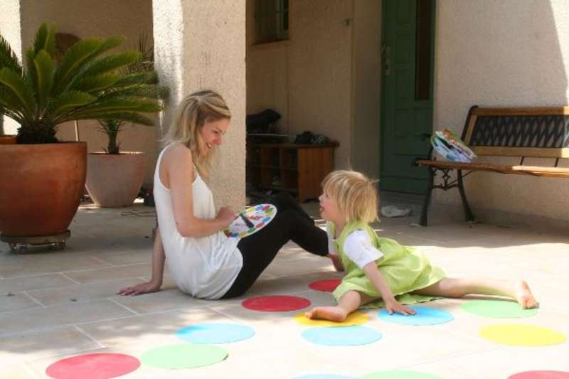 A mother playing twister with her daughter
