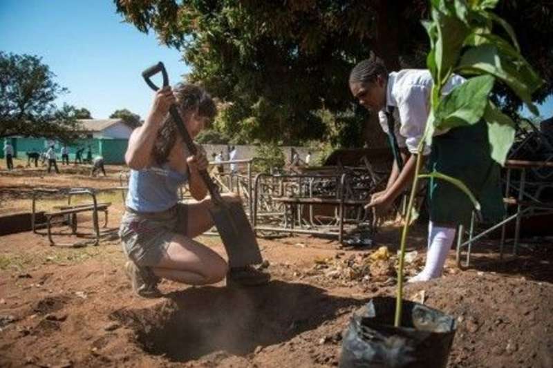 Volunteer and a child digging