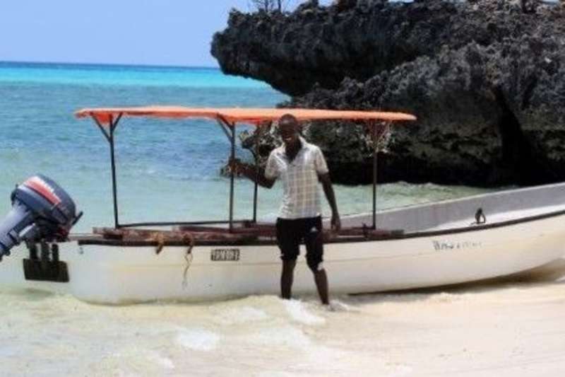 An image of a man stood next to boat