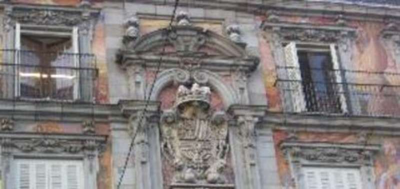 A building with numerous windows and a large clock on the side.