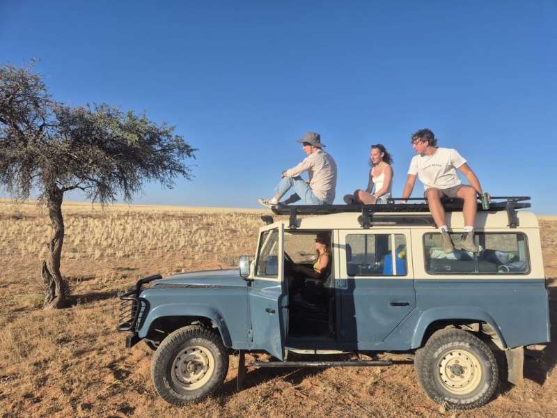 A car with an intern driving and other interns sat on the roof in Aus