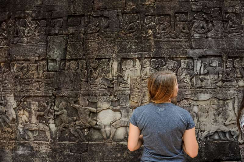 A girl admiring stone carvings in Cambodia