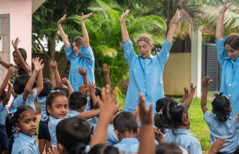 A group of children playing outdoors with volunteers