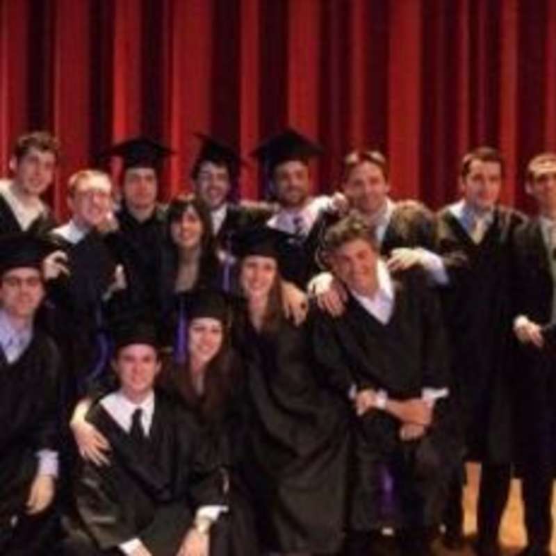 A group of graduates smiling and posing for a photo.