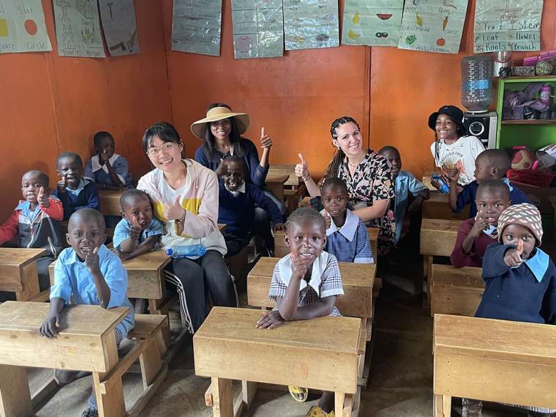 a group of women with local school children