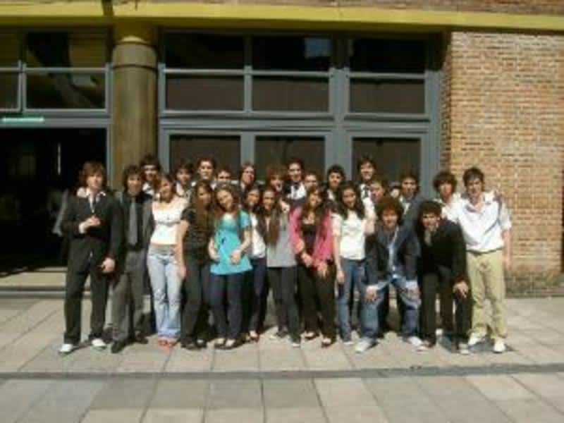 A group of young people posing in front of a building.