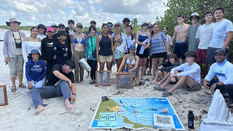 A group picture of people on the beach during beach cleanup.