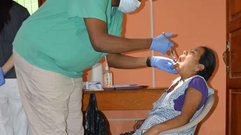 A Male Volunteer giving an Elderly Patient an Injection 