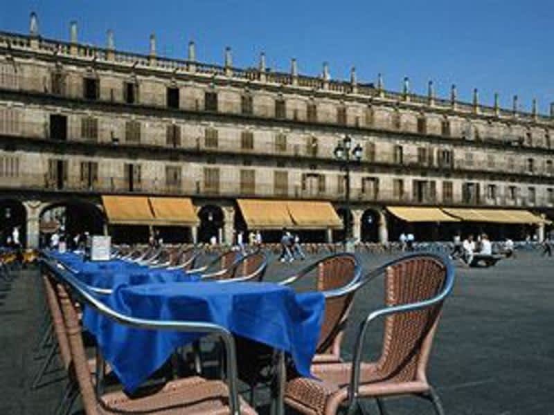 A spacious square with outdoor seating in front of a building.