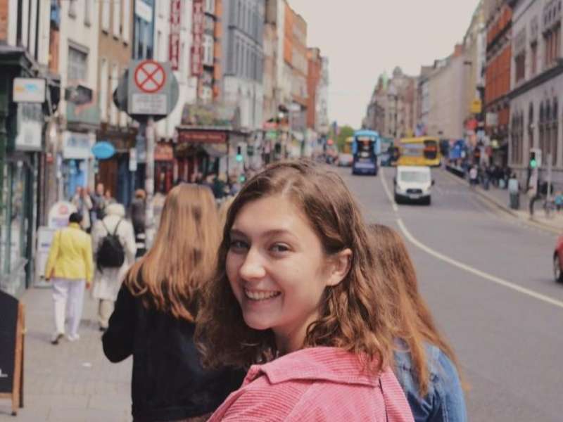 A student in Temple Bar turning around while walking and smiling