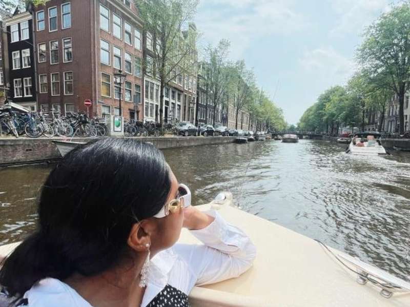A student looks back at the canal on a boat ride in Amsterdam.